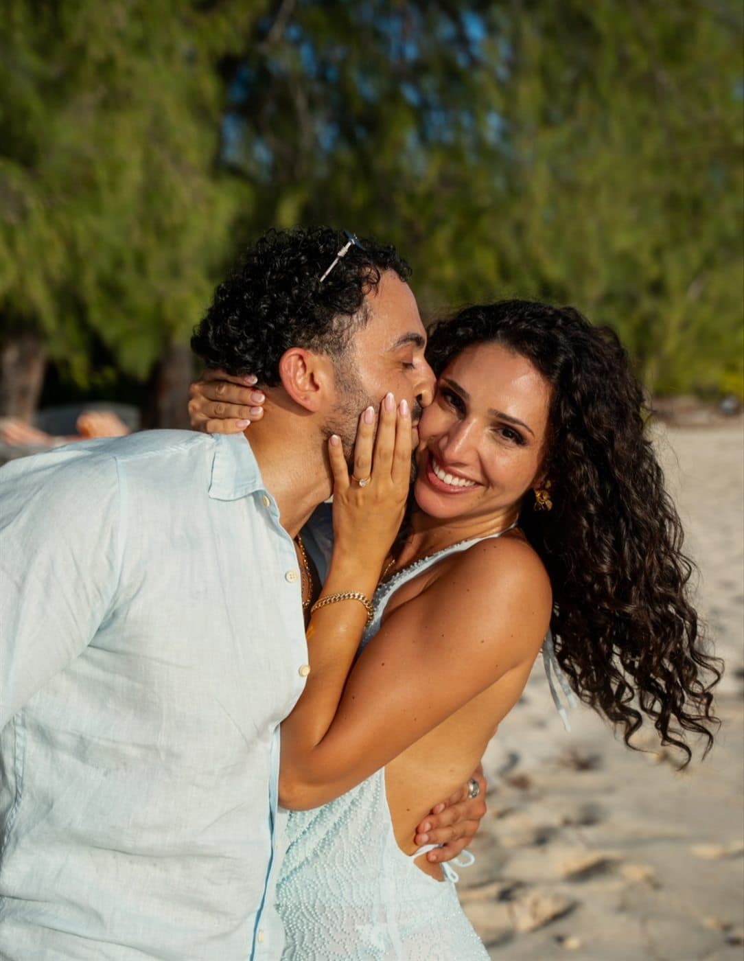 Carlos and Maise smiling together on the beach